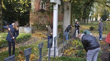 Jugendliche bei einem Pflegeeinsatz auf der Kriegsgräberstätte in Wittenburg am 01. November 2025