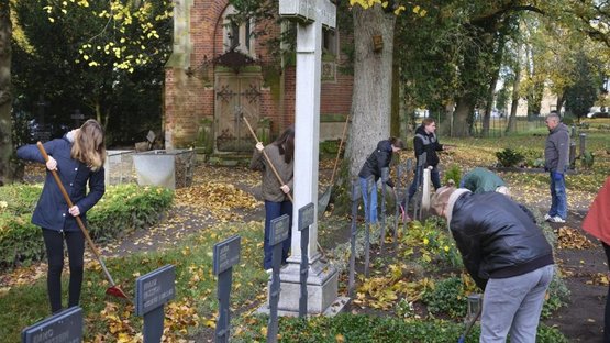 Jugendliche bei einem Pflegeeinsatz auf der Kriegsgräberstätte in Wittenburg am 01. November 2025